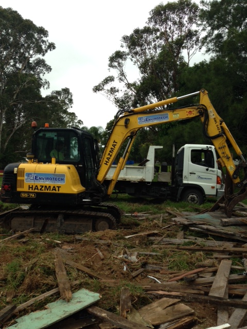 Excavator participating in site clean up